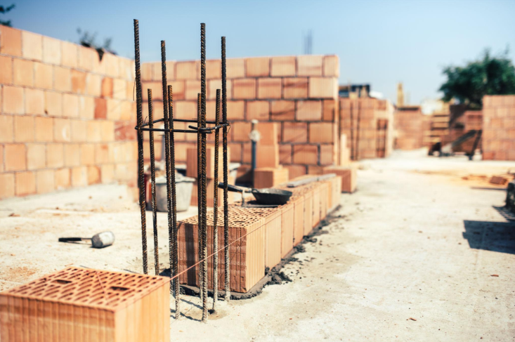 “Brick masonry wall under construction with reinforced rebar columns and clean block alignment during a masonry service in Pearland, TX”