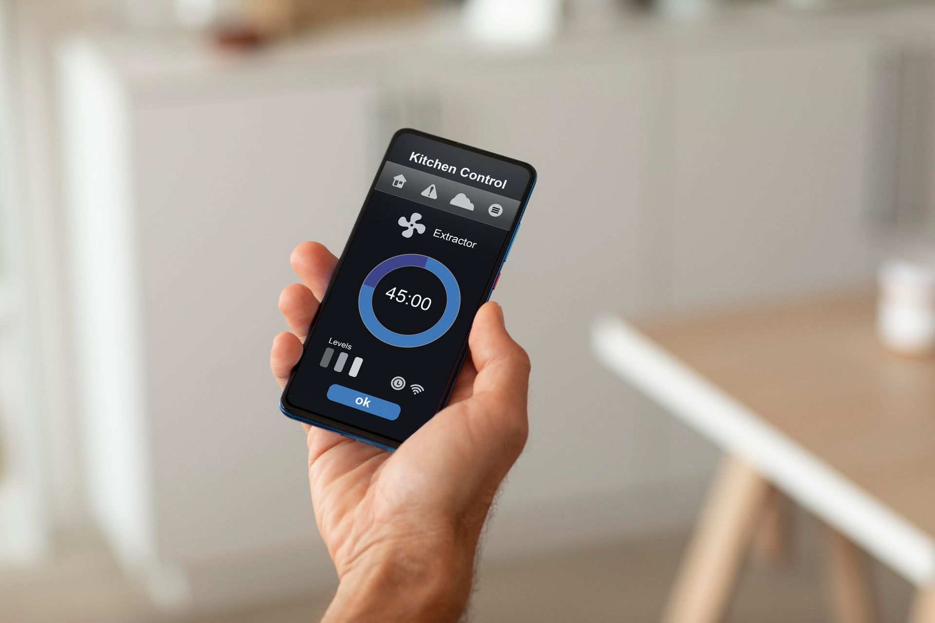 Hand holding a smartphone displaying an air control interface, indoors.