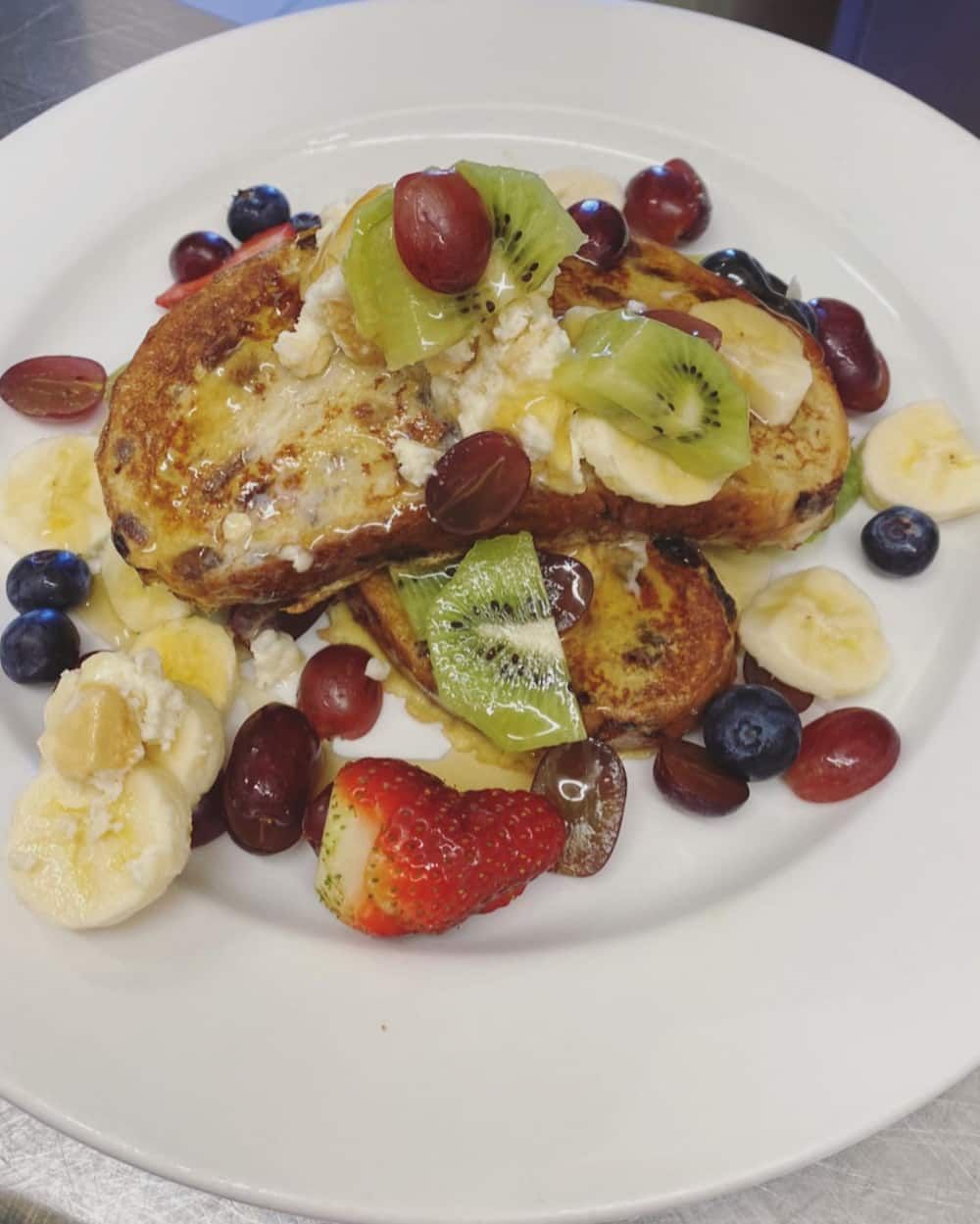 A White Plate Topped With French Toast And Fruit — Vines at 139 in Grafton, NSW