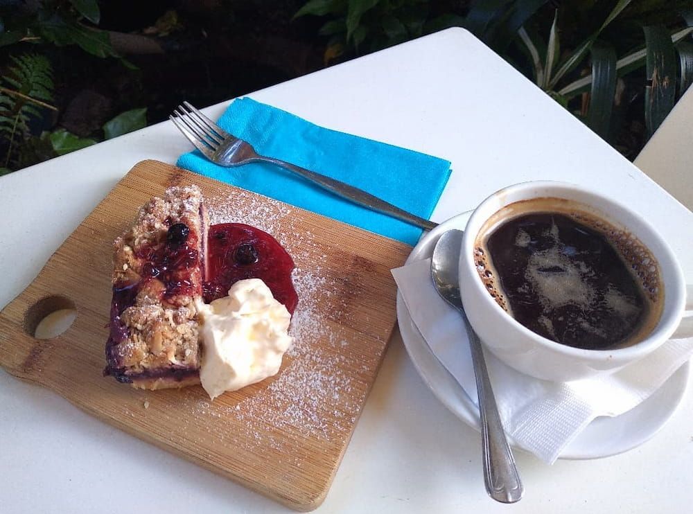A Piece Of Pie On A Cutting Board Next To A Cup Of Coffee — Vines at 139 in Grafton, NSW