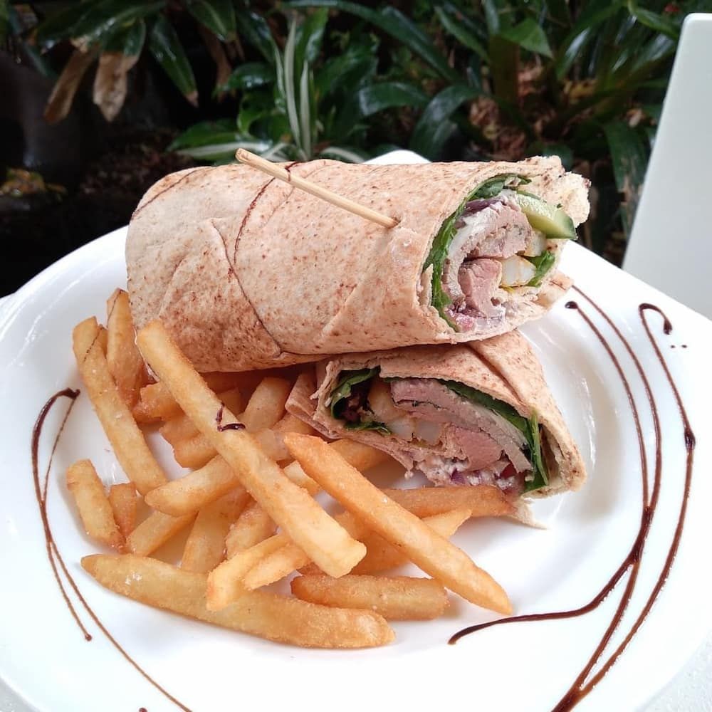 A White Plate Topped With A Wrap And French Fries — Vines at 139 in Grafton, NSW