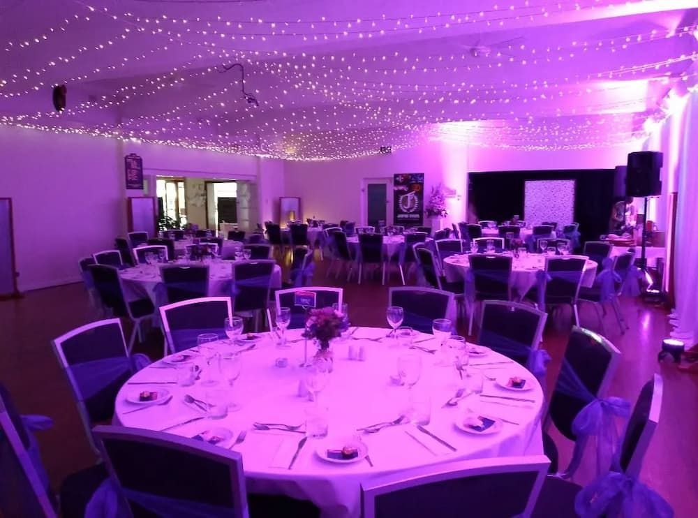 A Large Room Filled With Tables And Chairs With Purple Lights On The Ceiling — Vines at 139 in Grafton, NSW