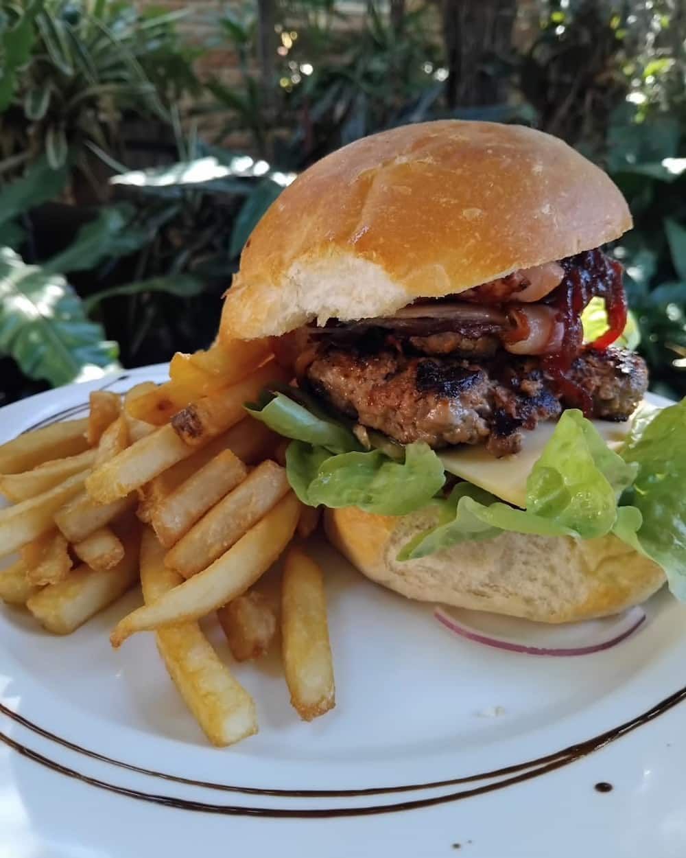 A White Plate Topped With A Hamburger And French Fries — Vines at 139 in Grafton, NSW