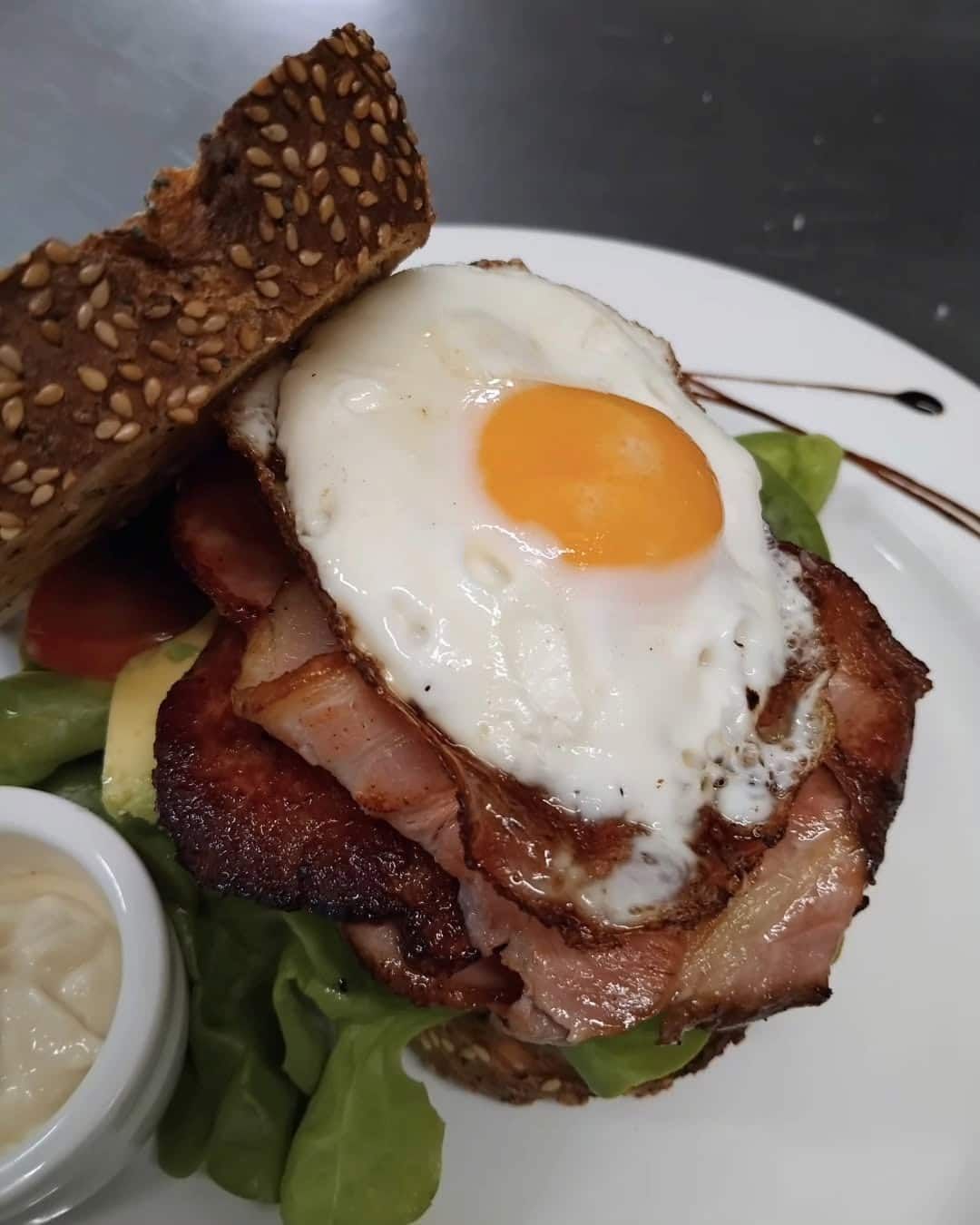 A Sandwich With Bacon Eggs And Lettuce On A Plate — Vines at 139 in Grafton, NSW