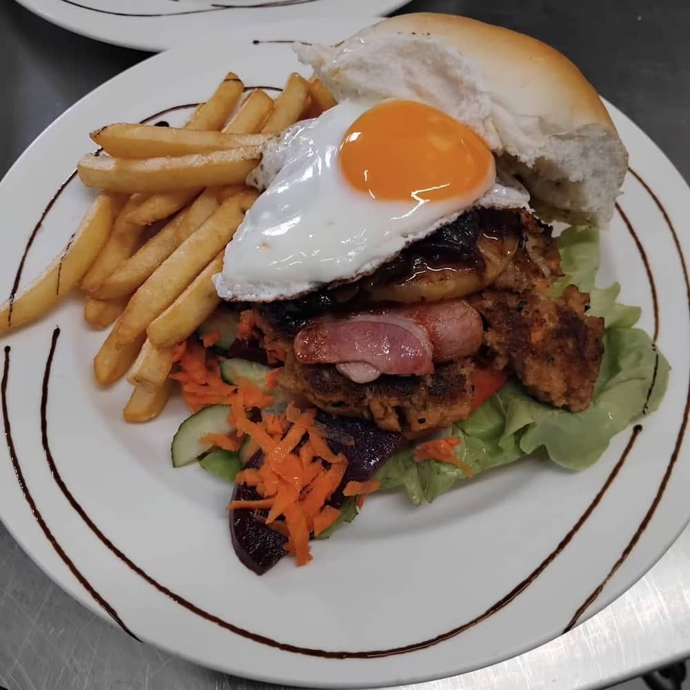 A White Plate Topped With A Hamburger And French Fries — Vines at 139 in Grafton, NSW