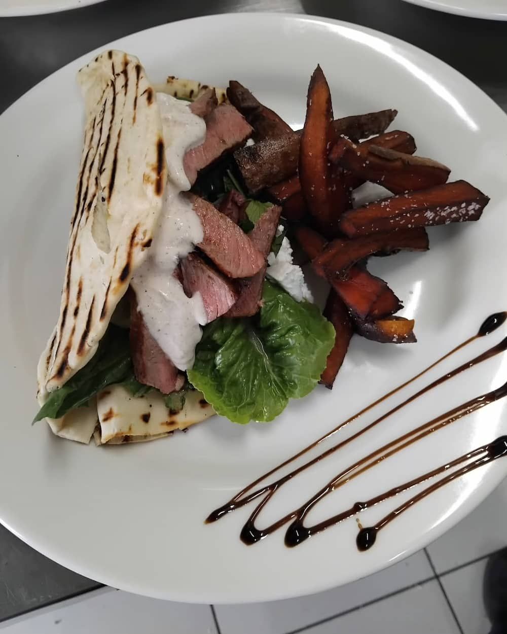 A White Plate Topped With A Wrap And French Fries — Vines at 139 in Grafton, NSW