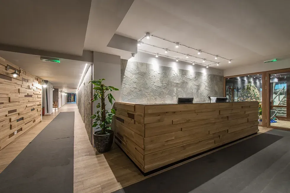 A long hallway with a wooden reception desk in the middle