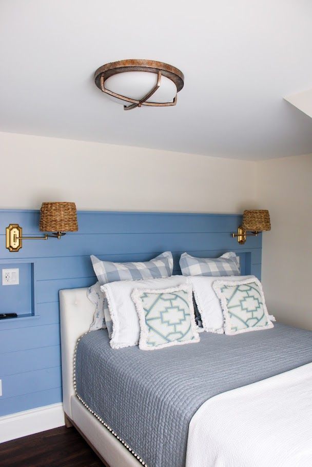 Blue and gray bedroom with striped bedding, coastal decor, and a woven ceiling light