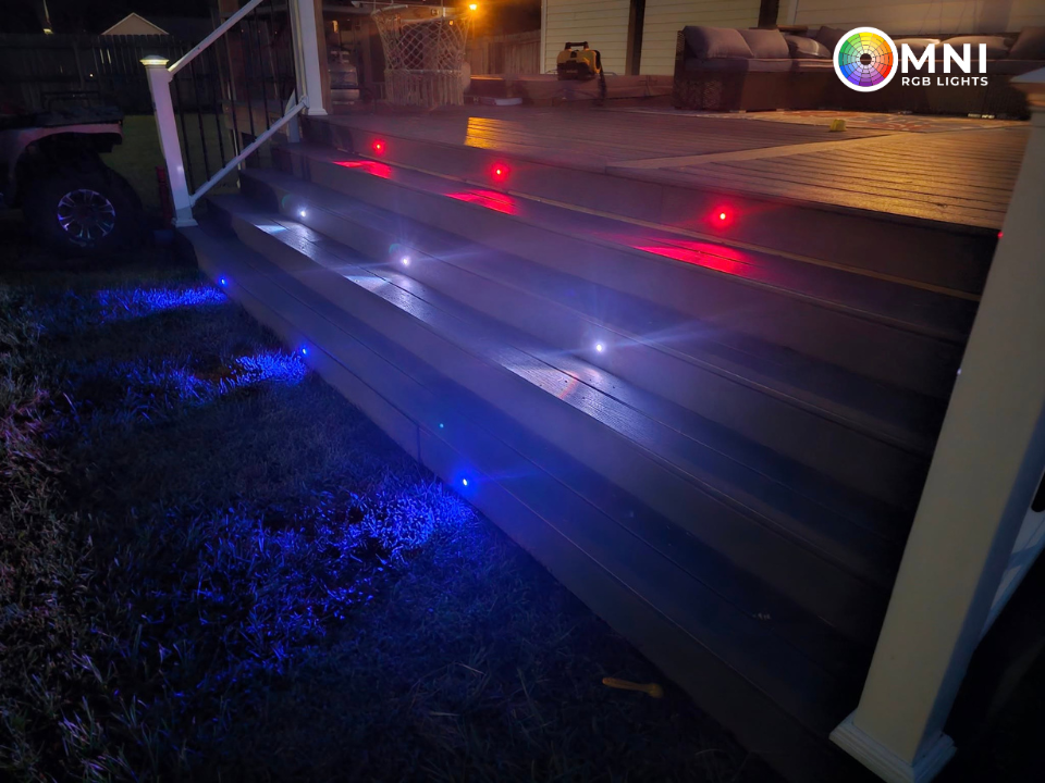 Front porch steps lit with red and blue decorative lights at night