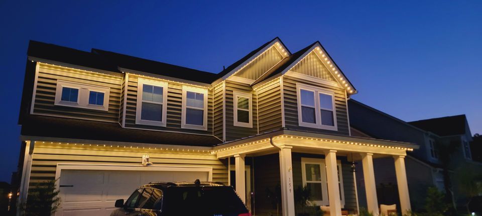 Two-story suburban house at dusk with warm exterior lights and a covered front porch