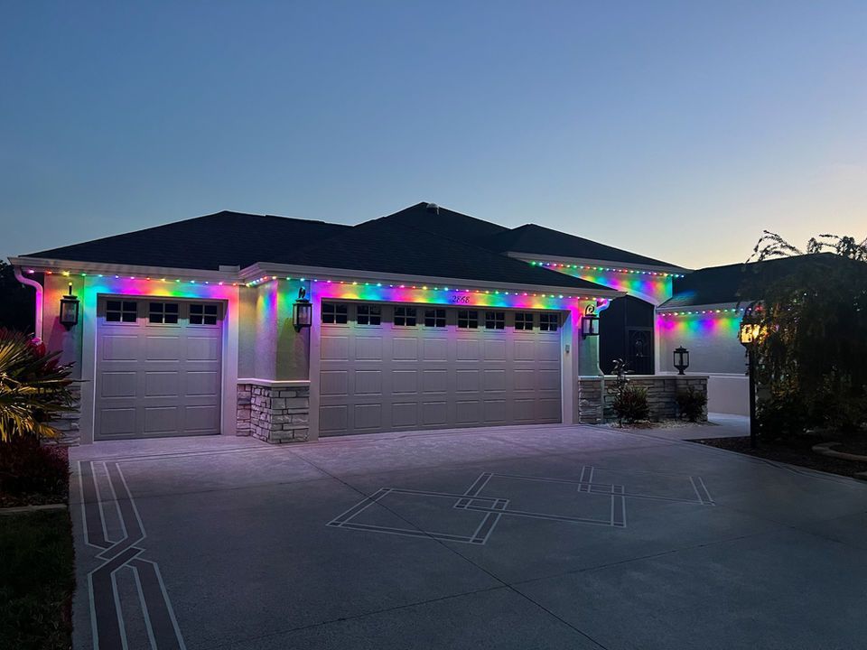 House with rainbow holiday lights along the roofline at dusk
