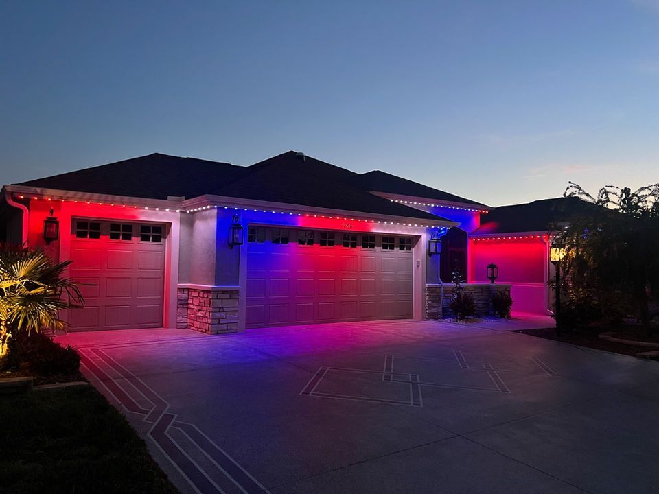 Suburban house at dusk with red and blue LED lights illuminating the garage and driveway