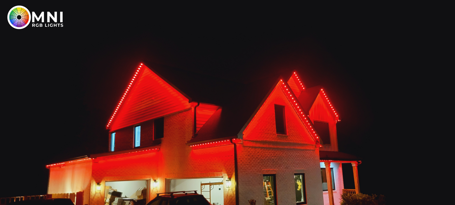 House at night illuminated with bright red roof lights against a dark sky
