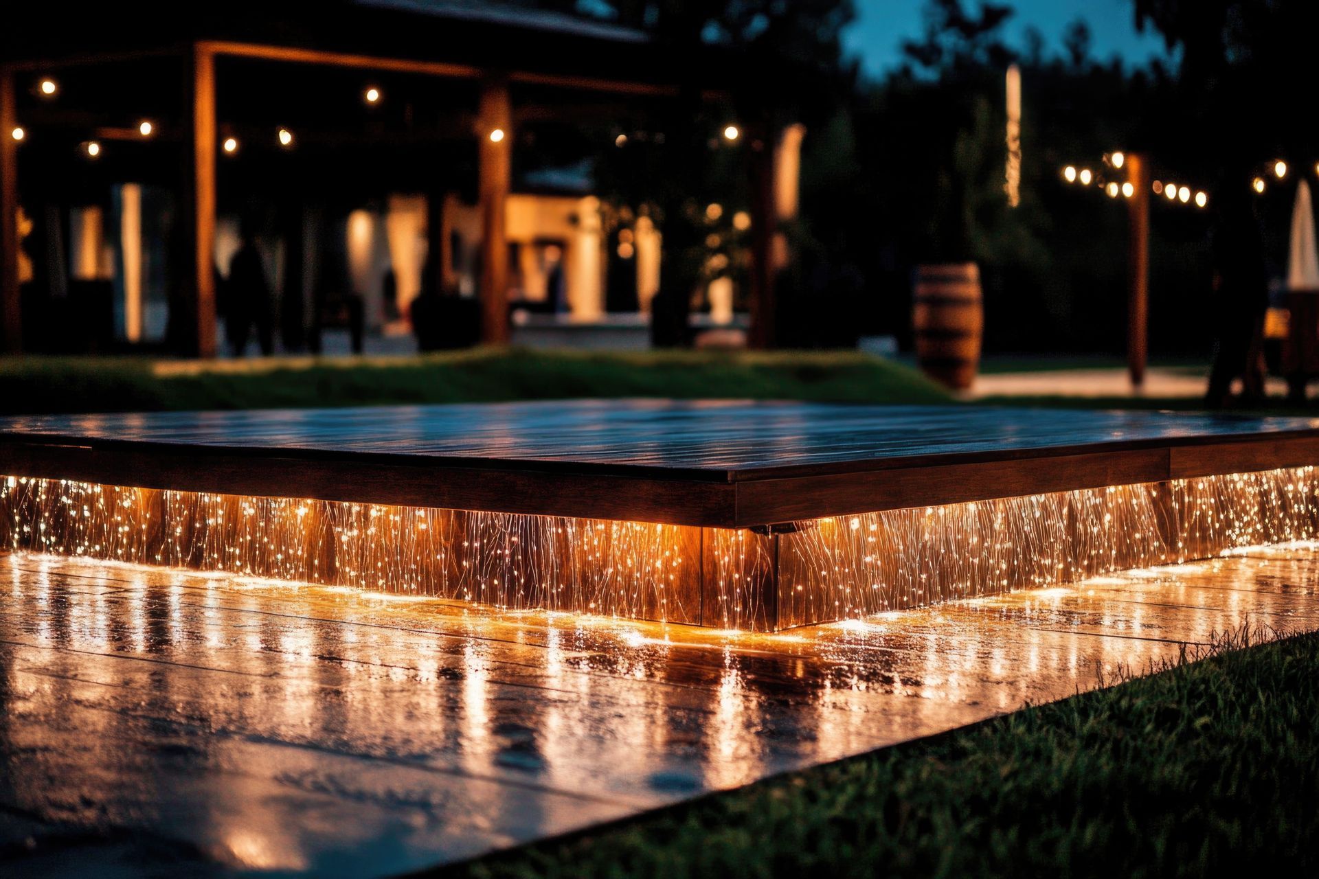 Illuminated outdoor pool with warm string lights reflecting on the water at dusk