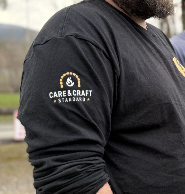 Black long-sleeve shirt with “Care & Craft Standard” logo on the sleeve