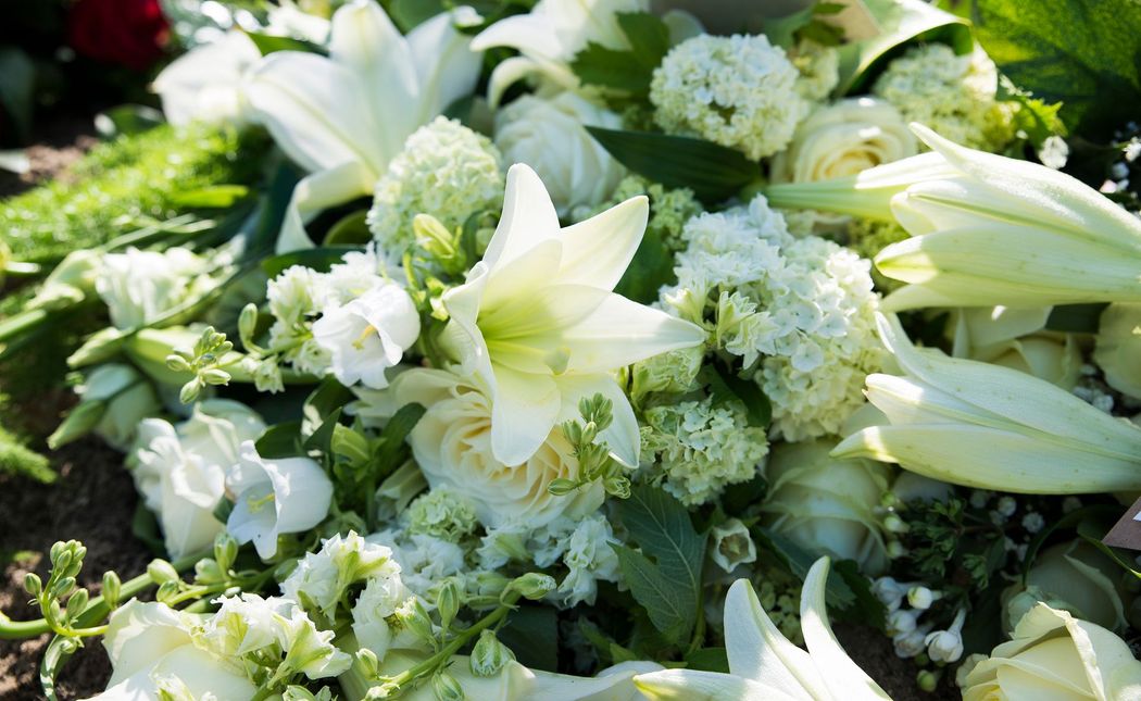 Gigli bianchi e ortensie verdi disposti in un bouquet di fiori freschi