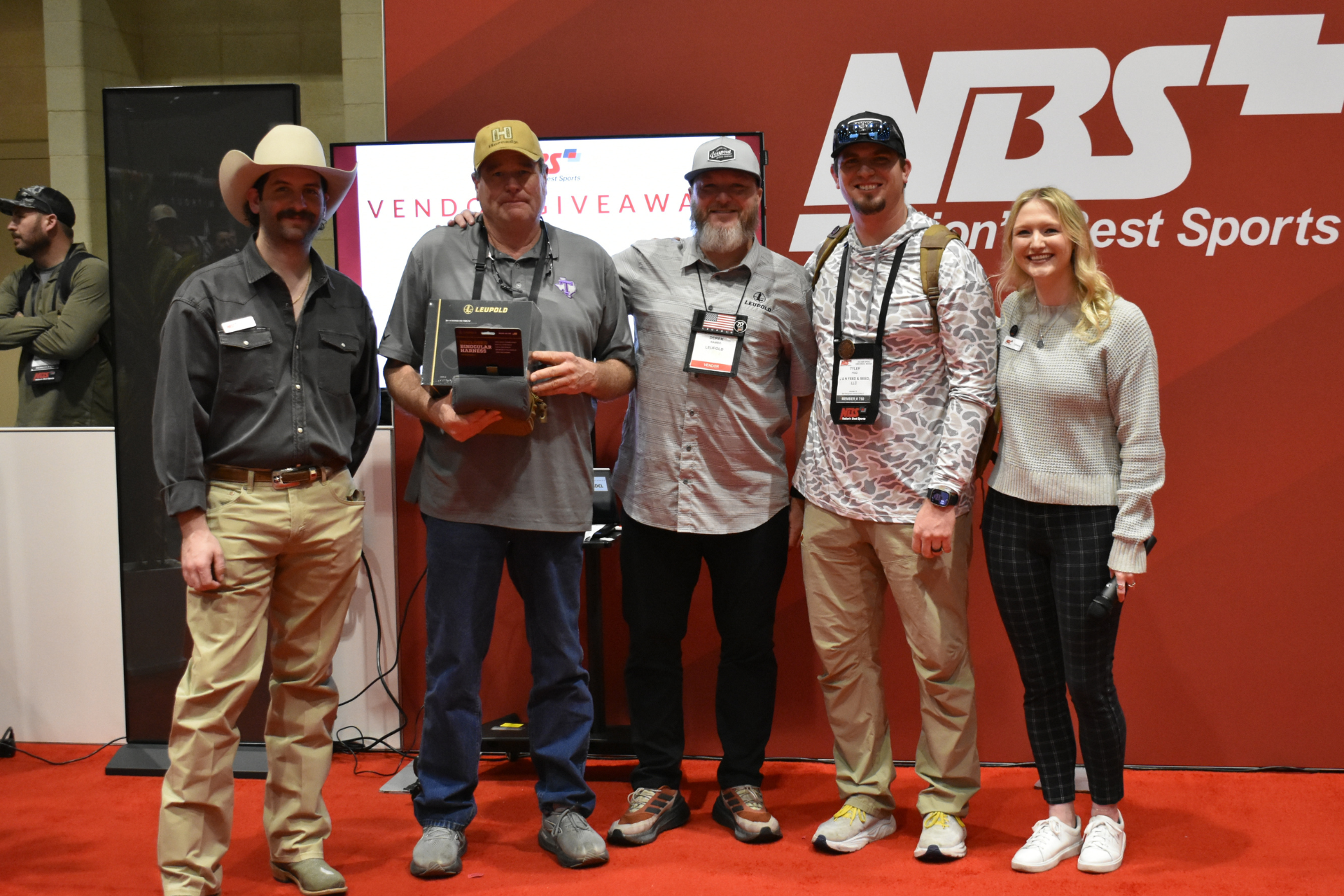 Five people stand on a red carpet holding an award plaque at an NRS event backdrop.