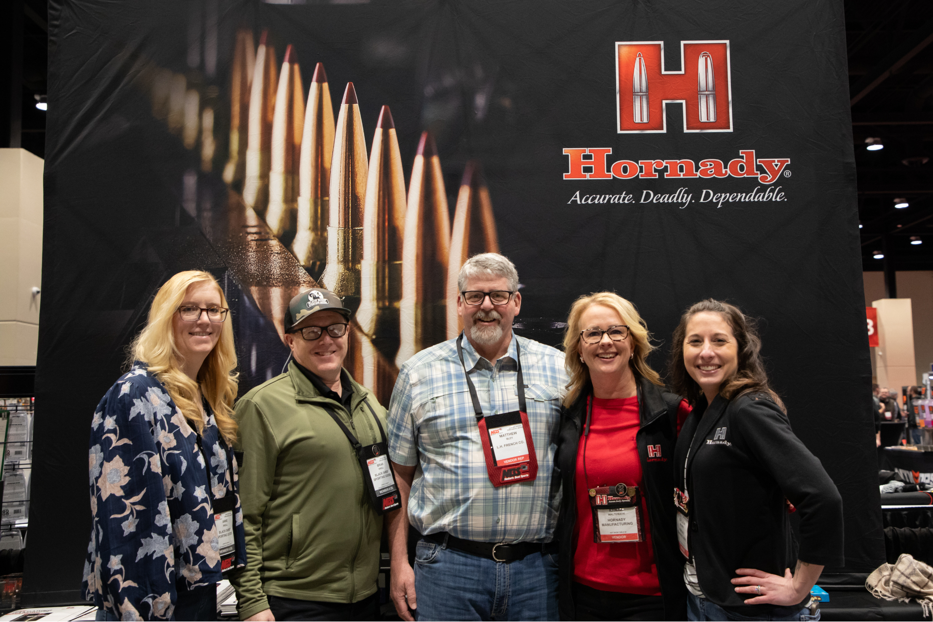 Five people posing in front of a Harrondy display at a trade show booth