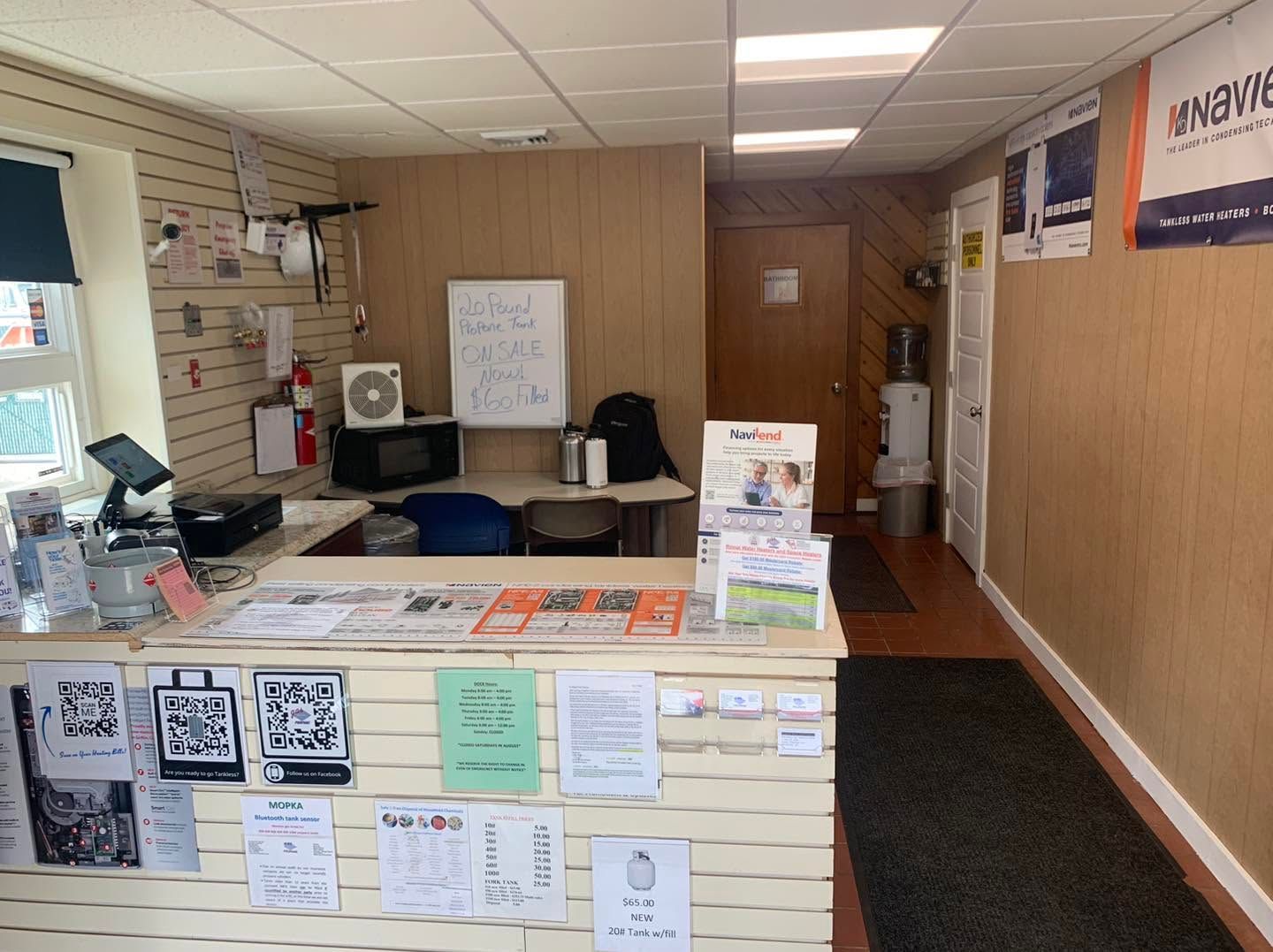 Front desk reception area with countertop, office chairs, bulletin boards, and hallway leading to a doorway