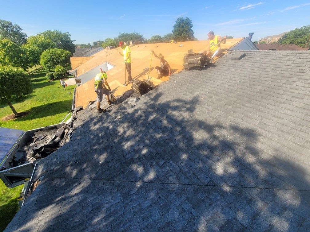 A group of men are working on the roof of a house.
