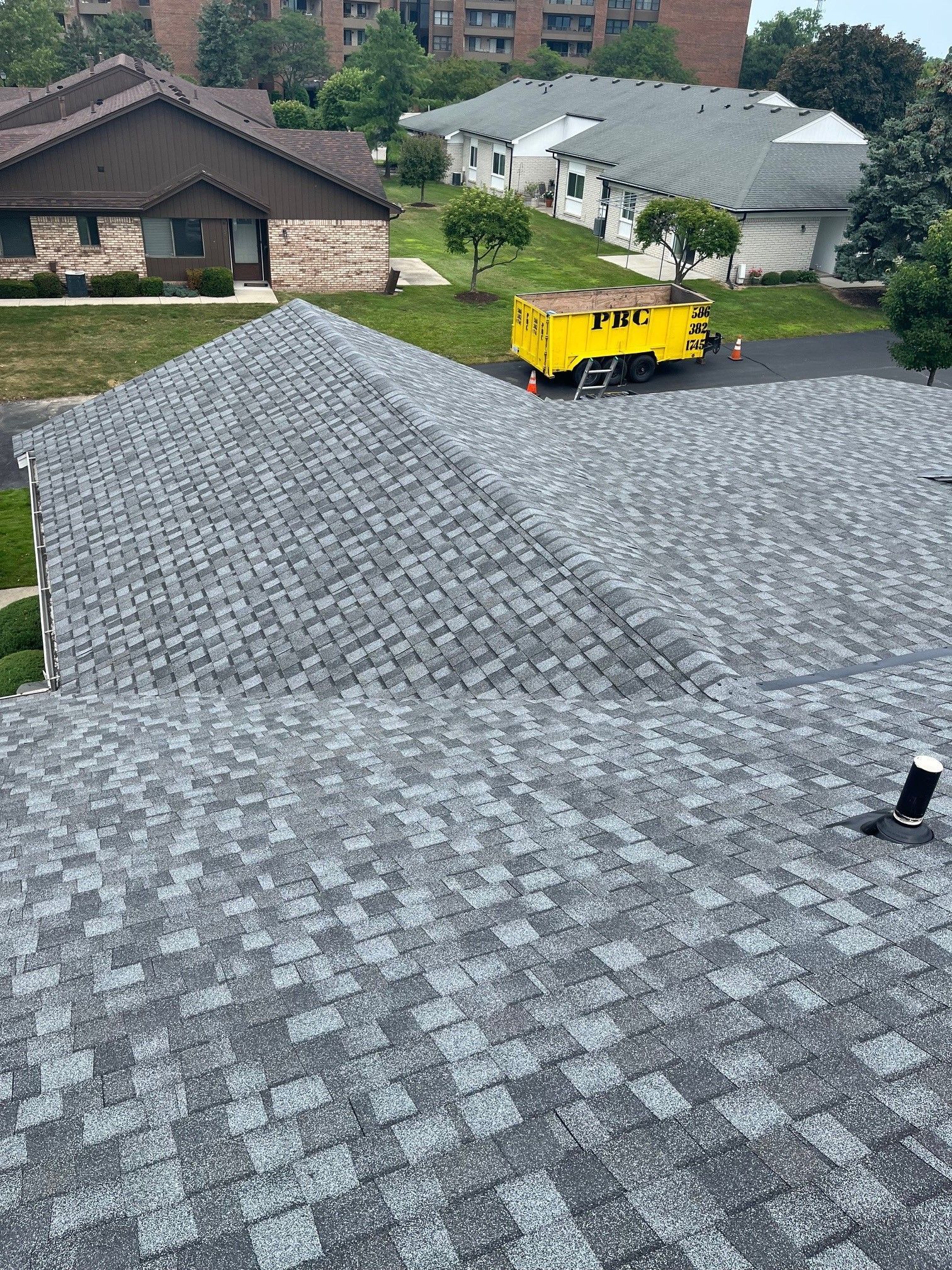 A yellow truck is parked on the roof of a house.