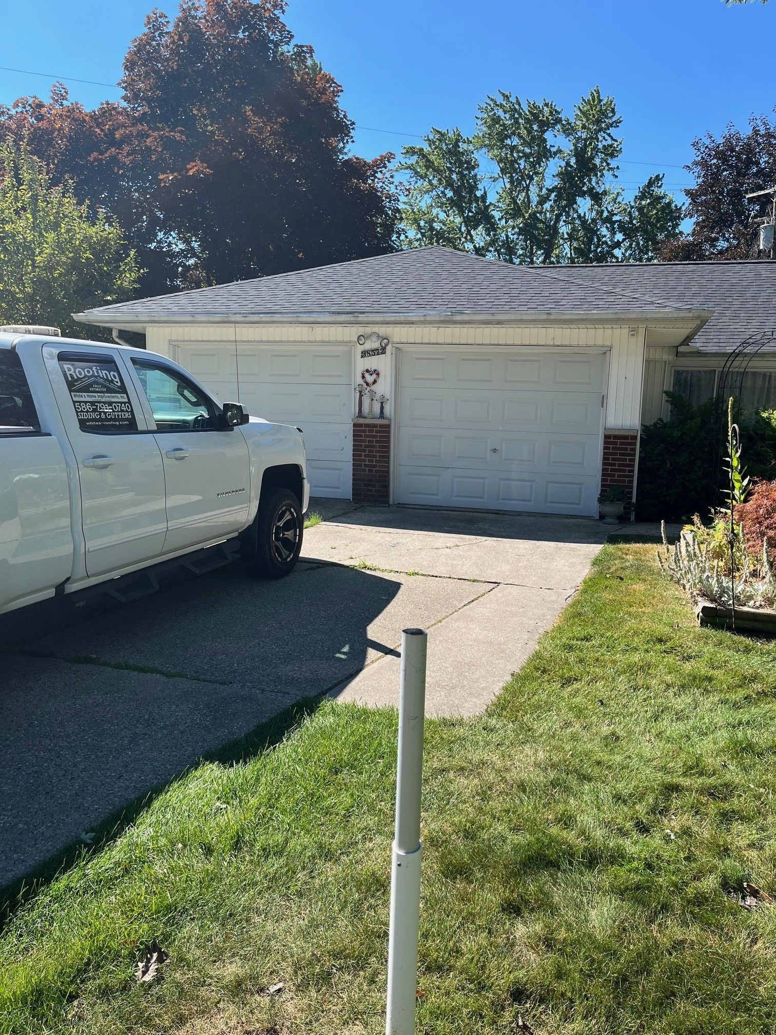 A white truck is parked in front of a house.