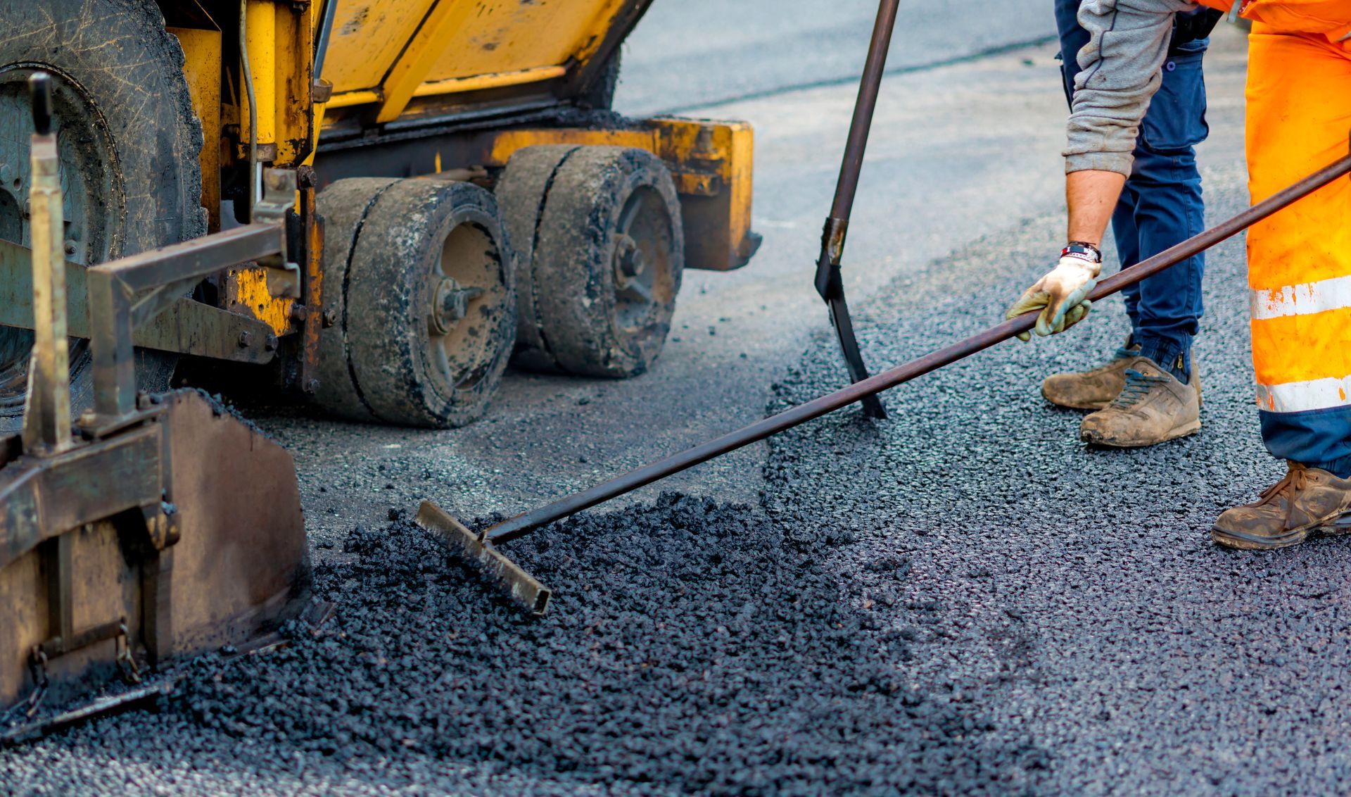 Workers are laying asphalt.