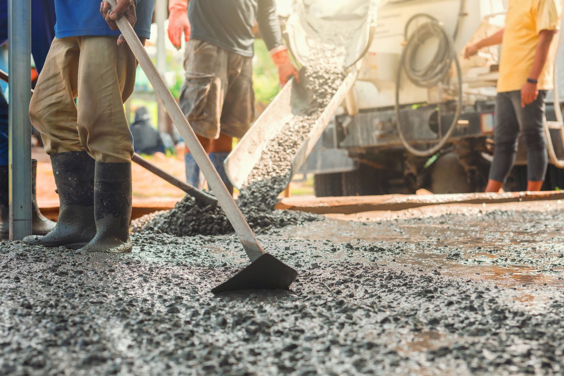 A group of construction workers is laying down concrete.