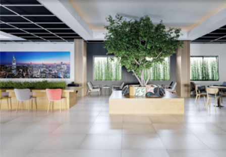 Lobby with a large indoor tree, seating, and cityscape mural. Bright space with white floor tiles and black ceiling grid.