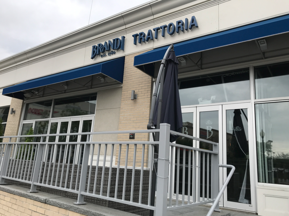 Bindi Trattoria restaurant with blue awning and outdoor seating area.