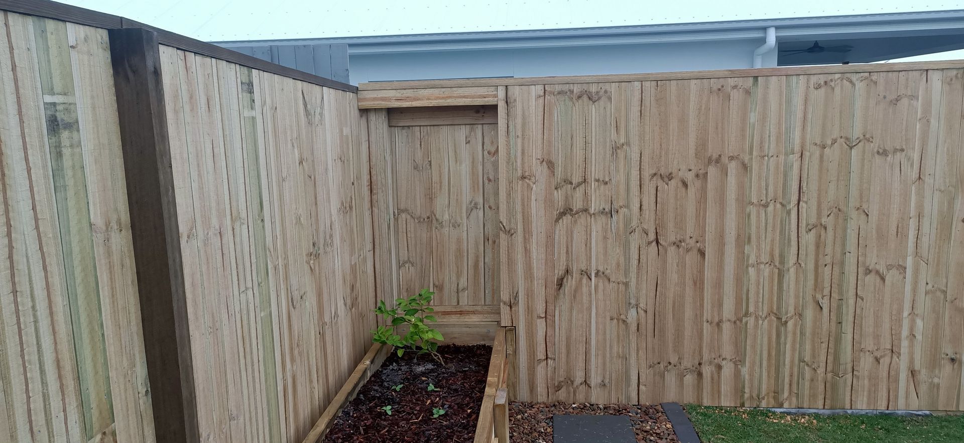 Bamboo fence with small planter box containing a small green plant — Quality Fences 4 U in Gympie, QLD