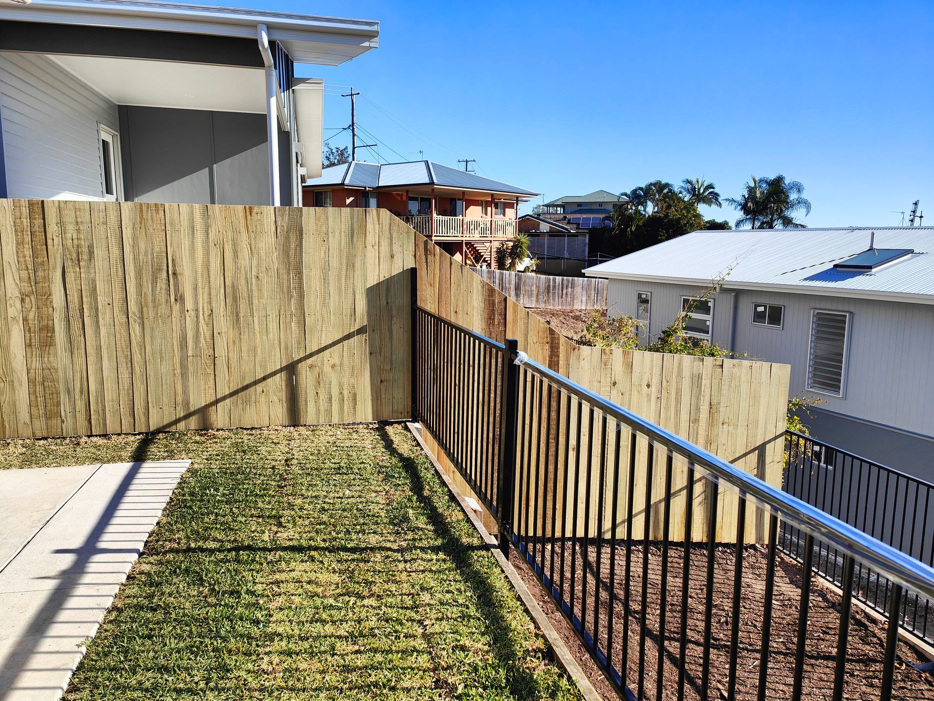 Backyard Patio Beside A Fenced Slope With Neighboring Houses And Ocean Views In The Distance — Quality Fences 4 U in Gympie, QLD