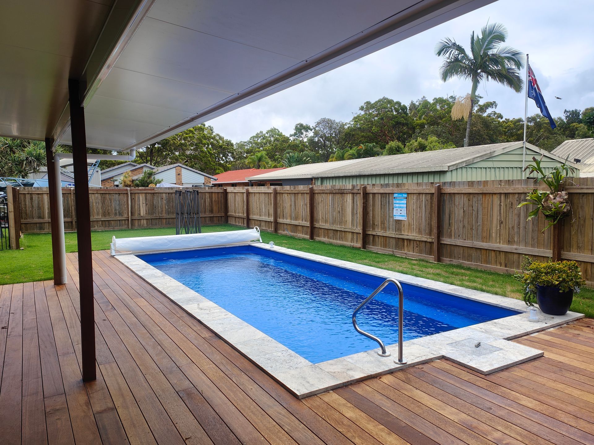 Covered Backyard Deck With A Small Blue Swimming Pool, Wooden Fence, And Overcast Sky — Quality Fences 4 U in Gympie, QLD