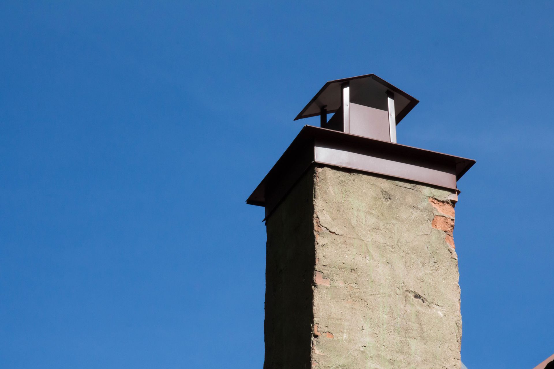 Cap on a cement chimney against blue sky – Macungie, PA - Anytime Todd's Chimney Sweeping