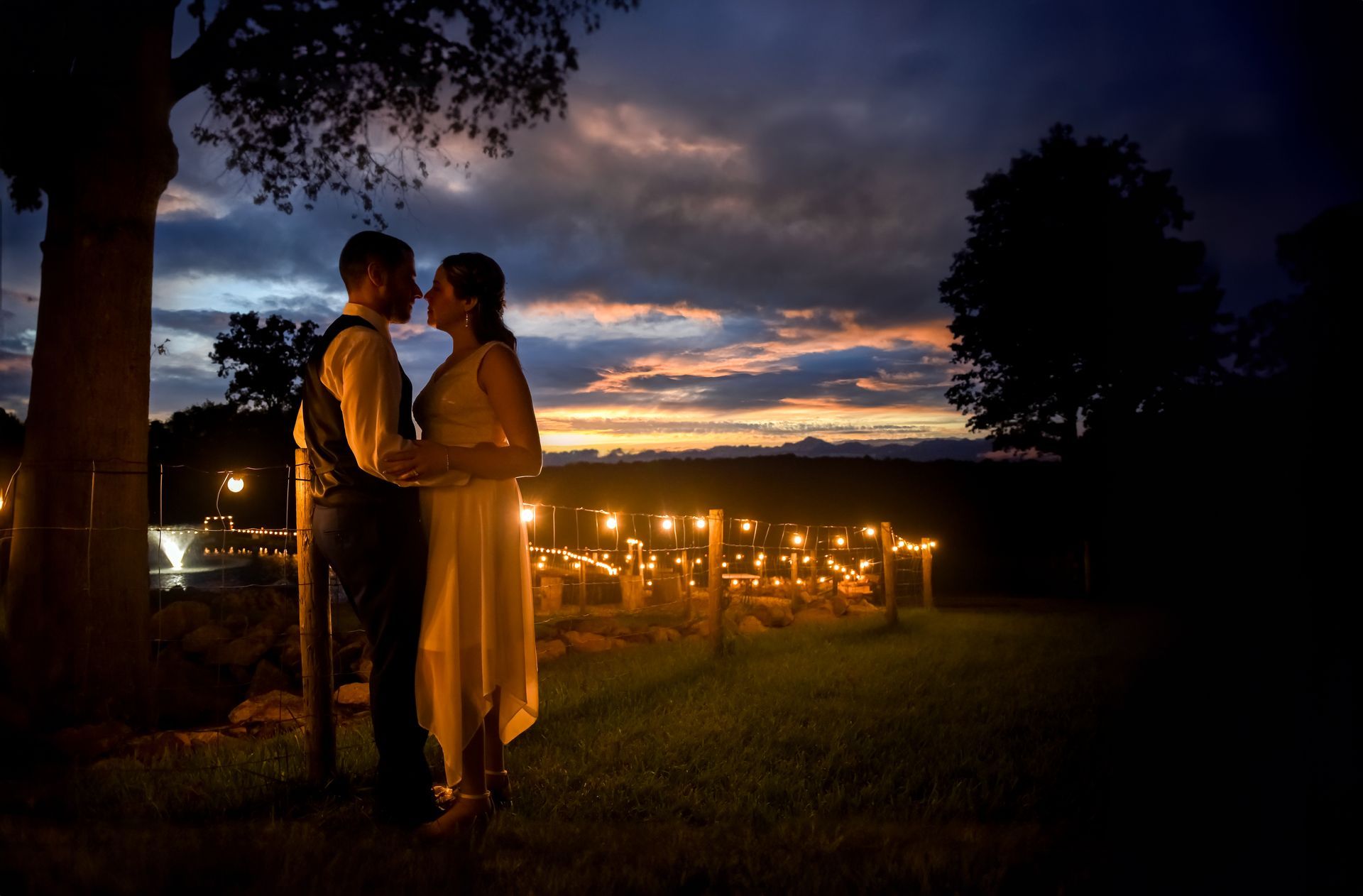 A bride and groom standing under a tree at sunset at Nuzzo's Farm  wedding photographed by Rogers Photography in Connecticut. 