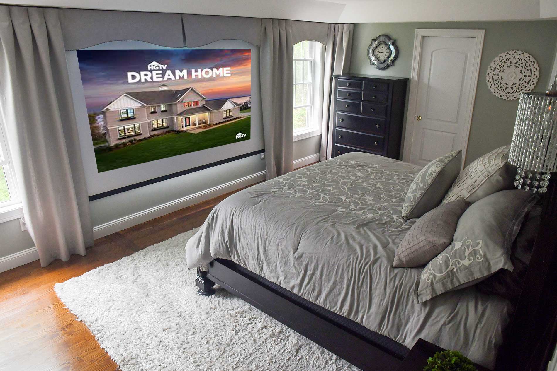 Cozy bedroom with a bed, white rug, gray decor, and a large window view of a house at dusk