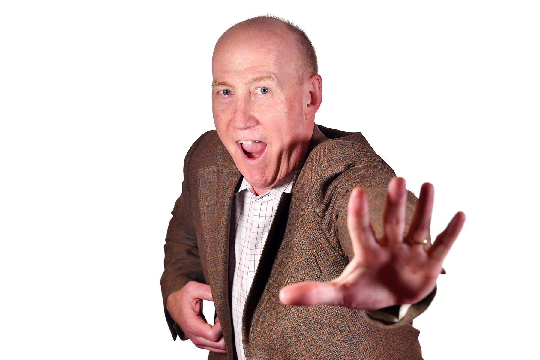 Business Portrait of Bald man in brown tweed jacket reaches toward camera with outstretched hand against white background
