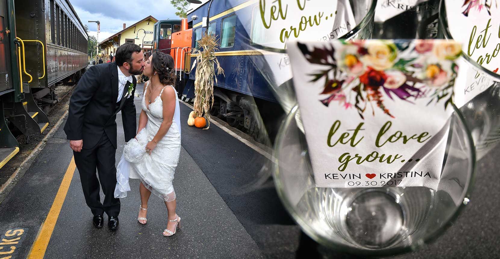 Bride and groom walking in the rain beside a train, with a “let love grow” floral favor in foreground for a wedding album.