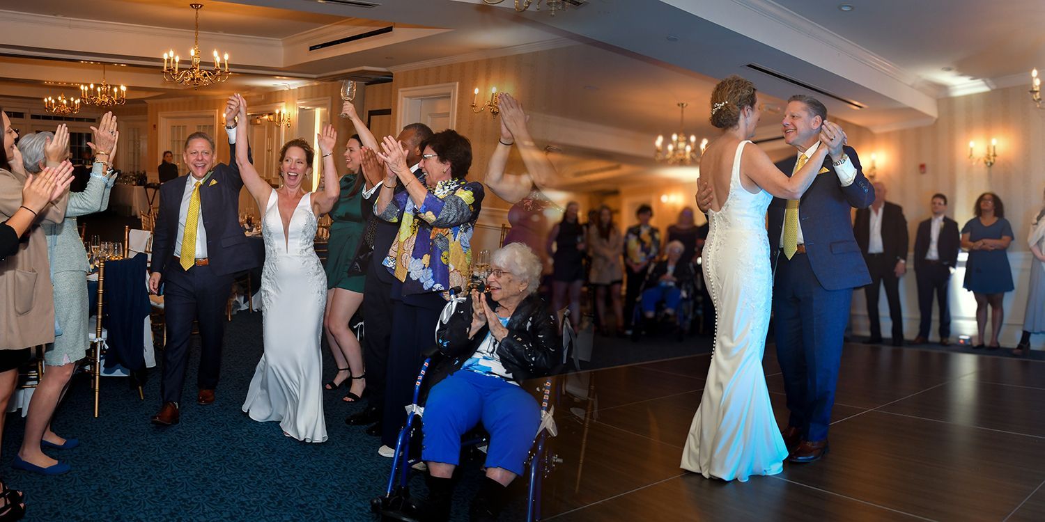 Wedding guests dance under warm lights in a banquet hall, with a bride and groom in formal attire.