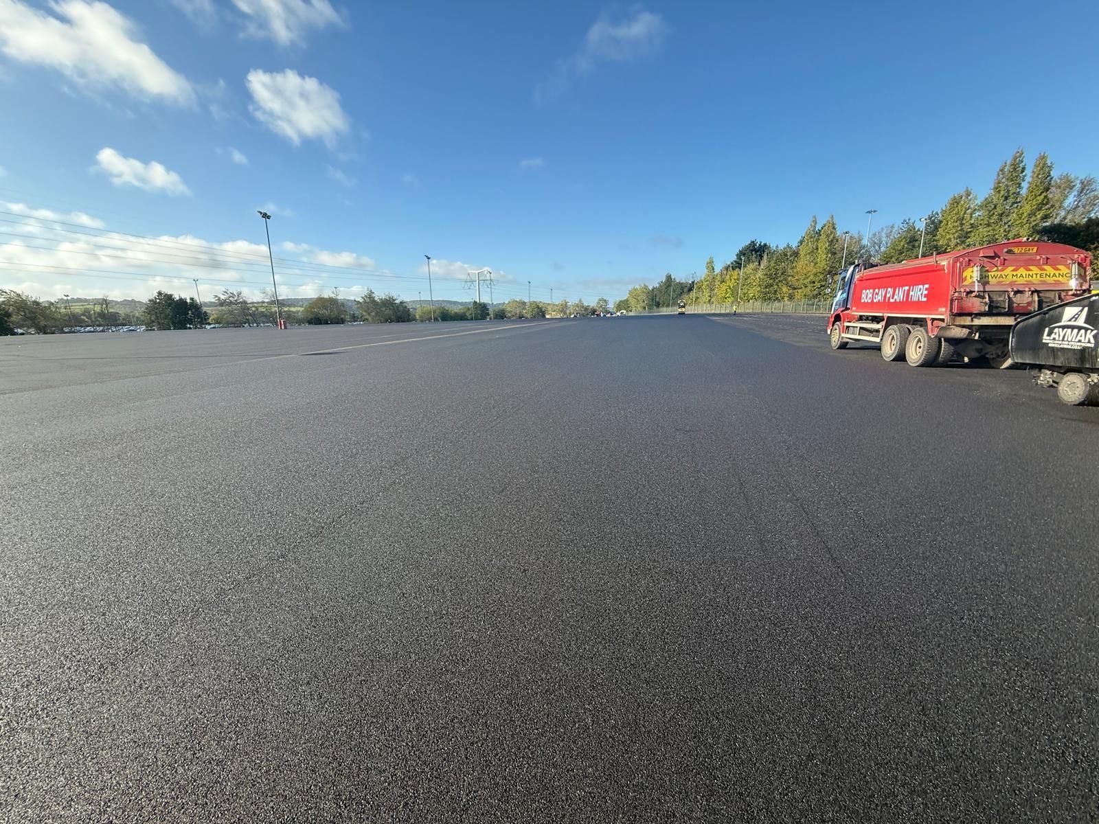 Asphalt surfacing plant working across a commercial car park
