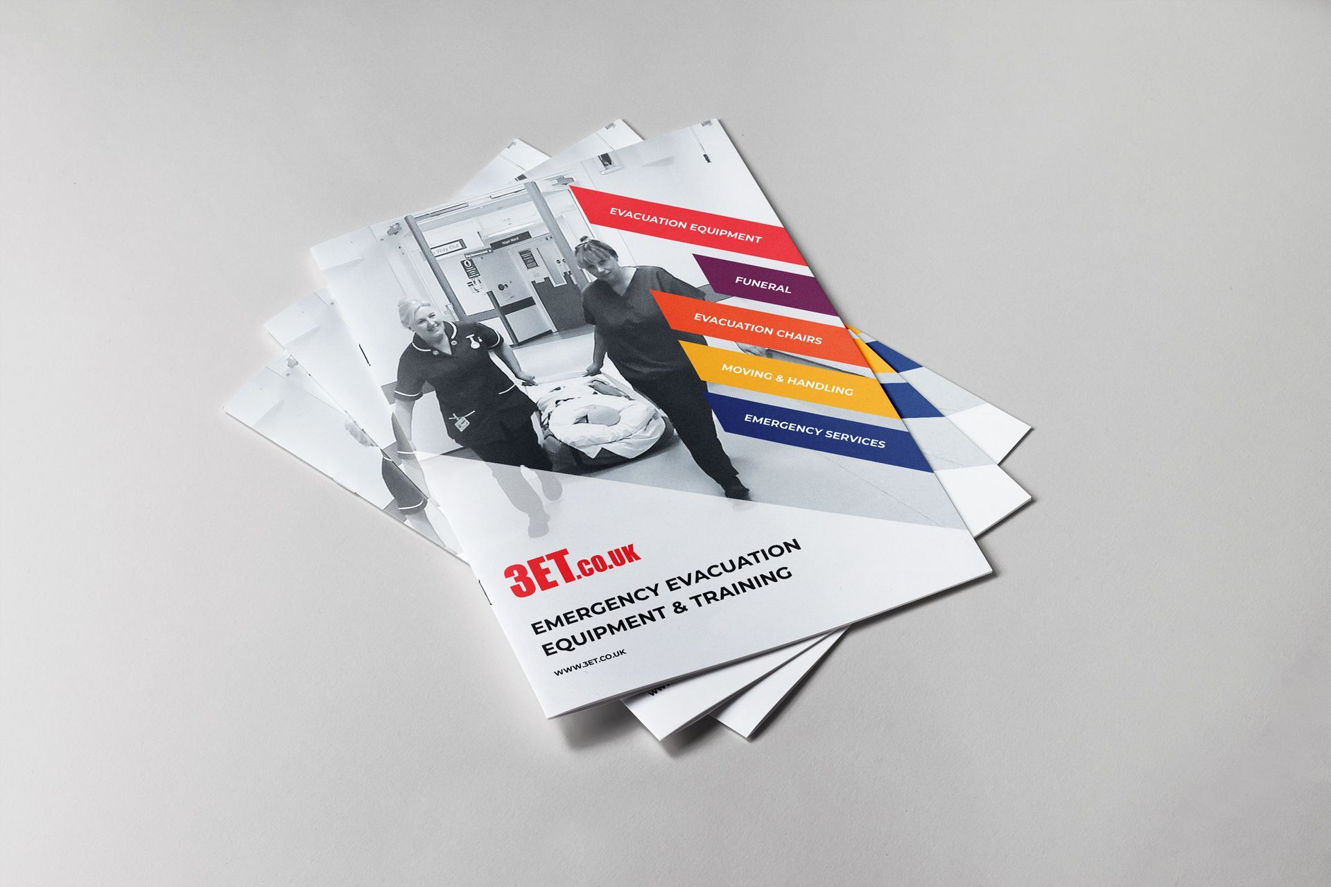 Stack of brochures with a person pushing a wheeled stretcher, colorful titles.