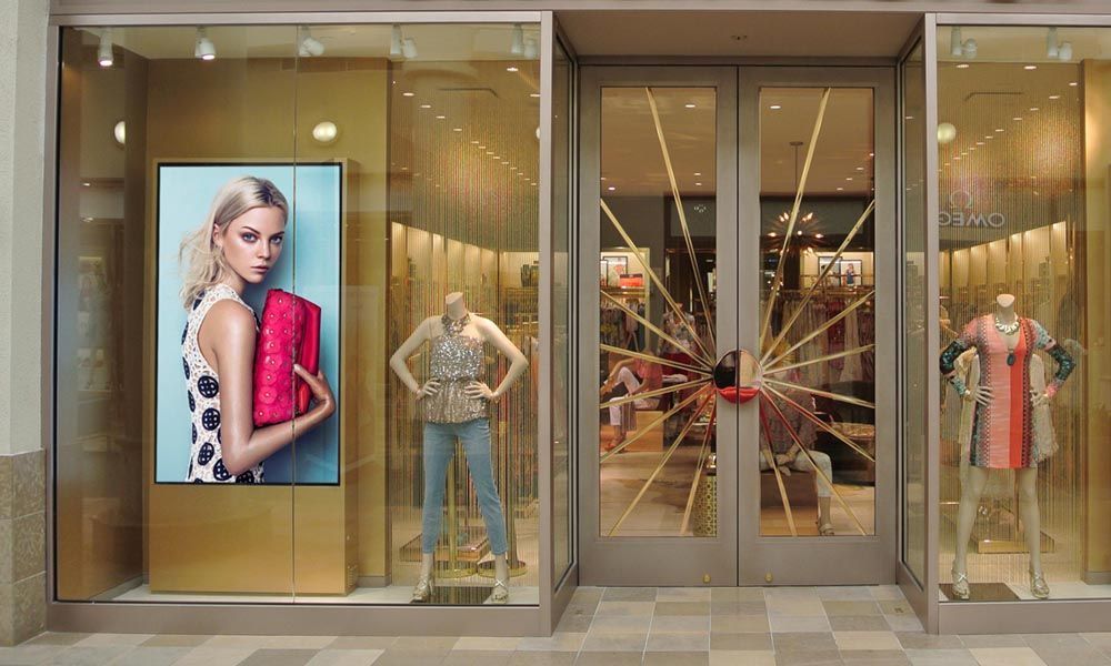 a store front with a broken glass door and mannequins in front of it