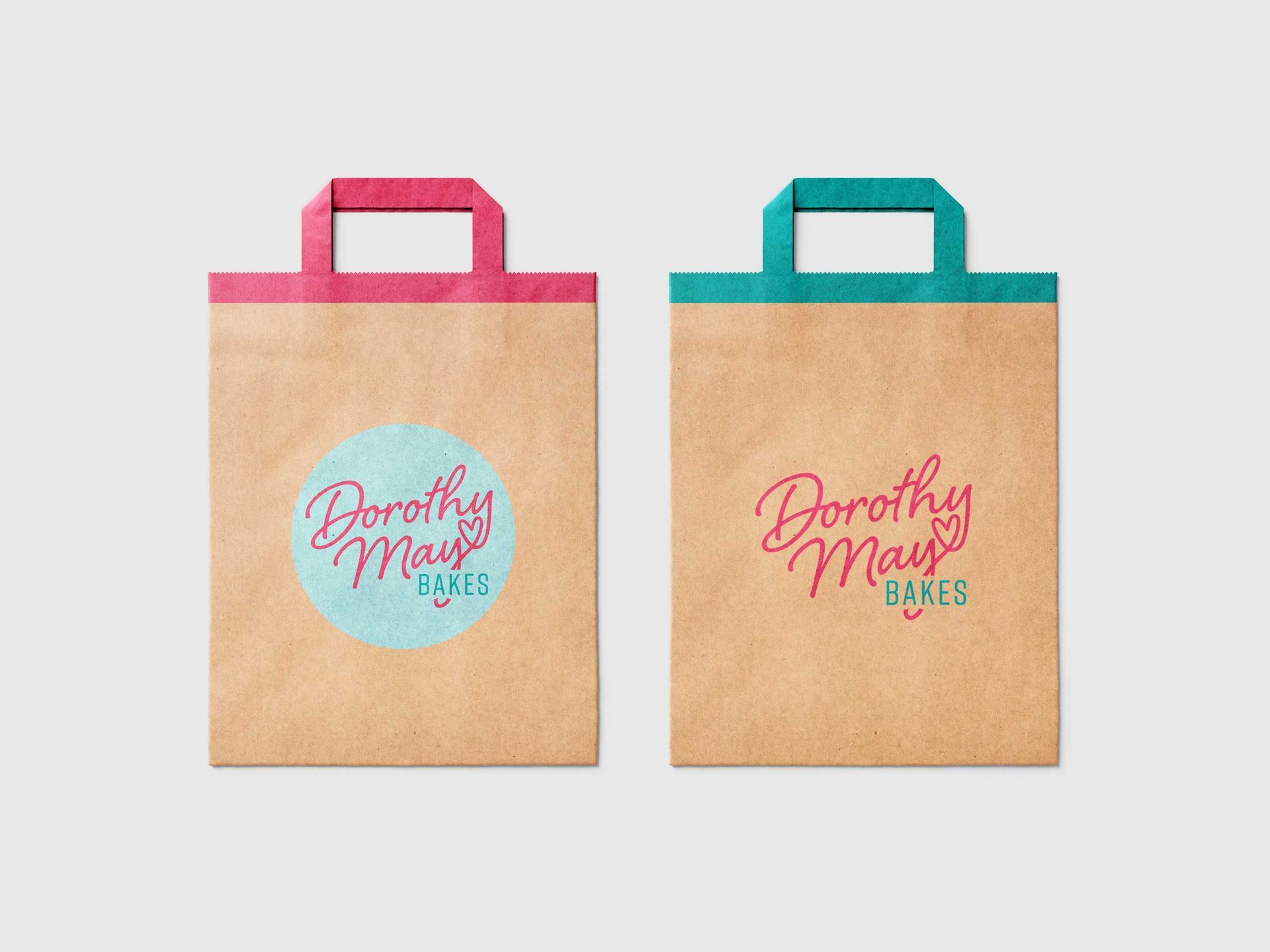 Two tan bakery bags with pink and teal handles and Dorothy May’s logo