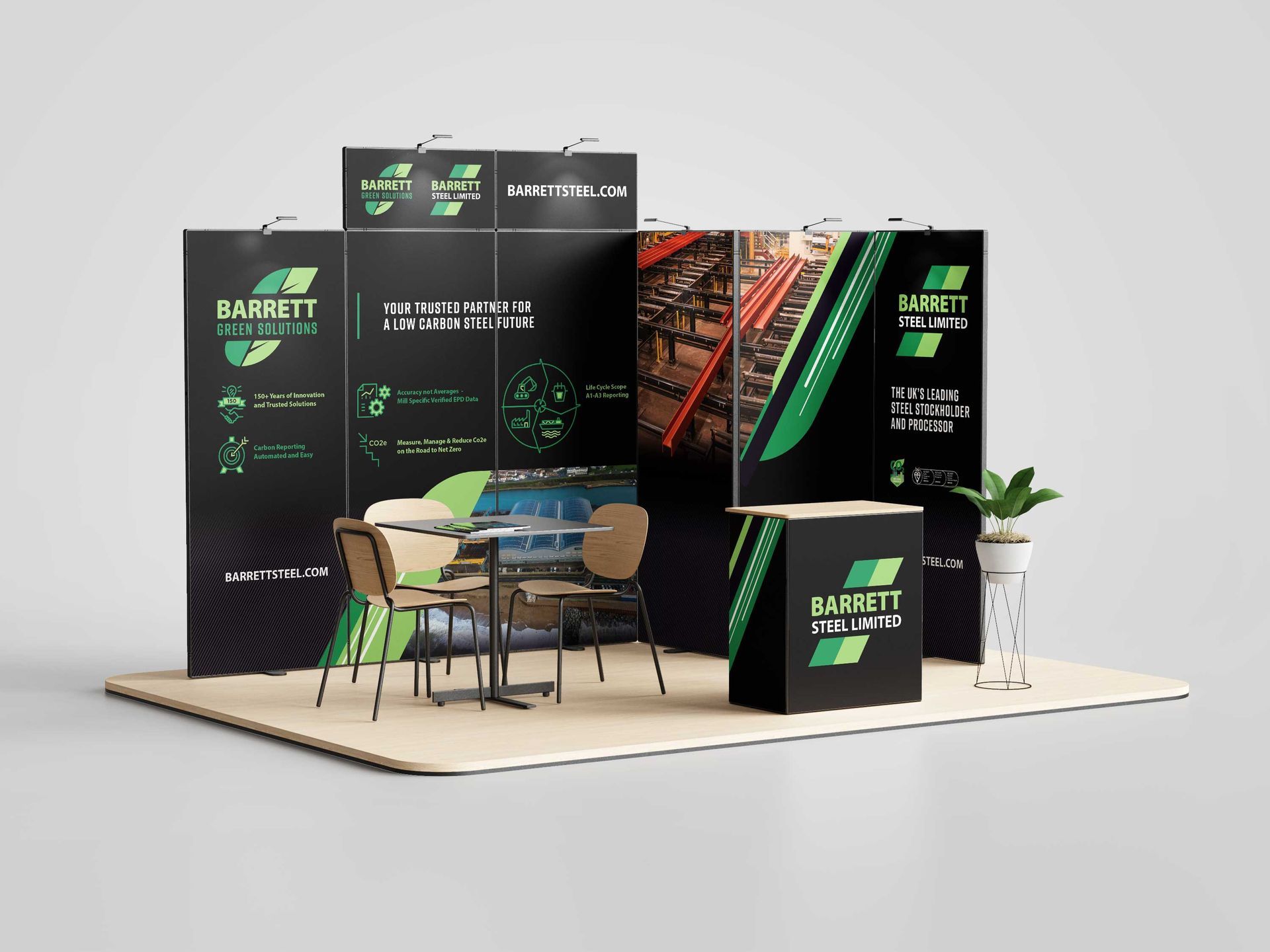 Black-and-green trade show booth with chairs, table, and potted plant on a light platform.