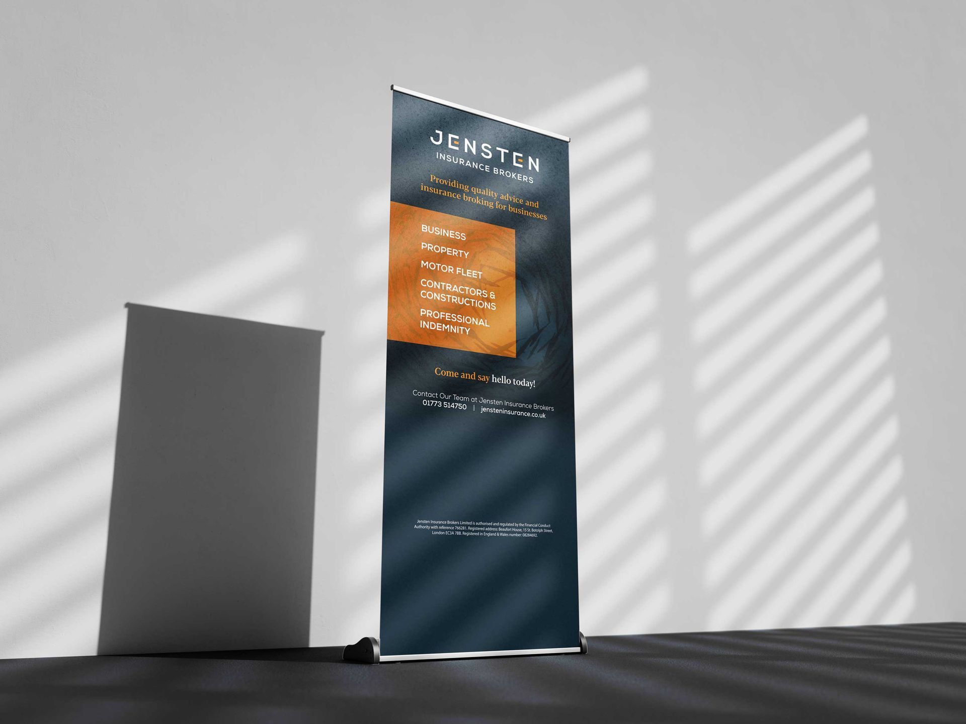 Tall blue and orange event banner beside a blank gray display in sunlight