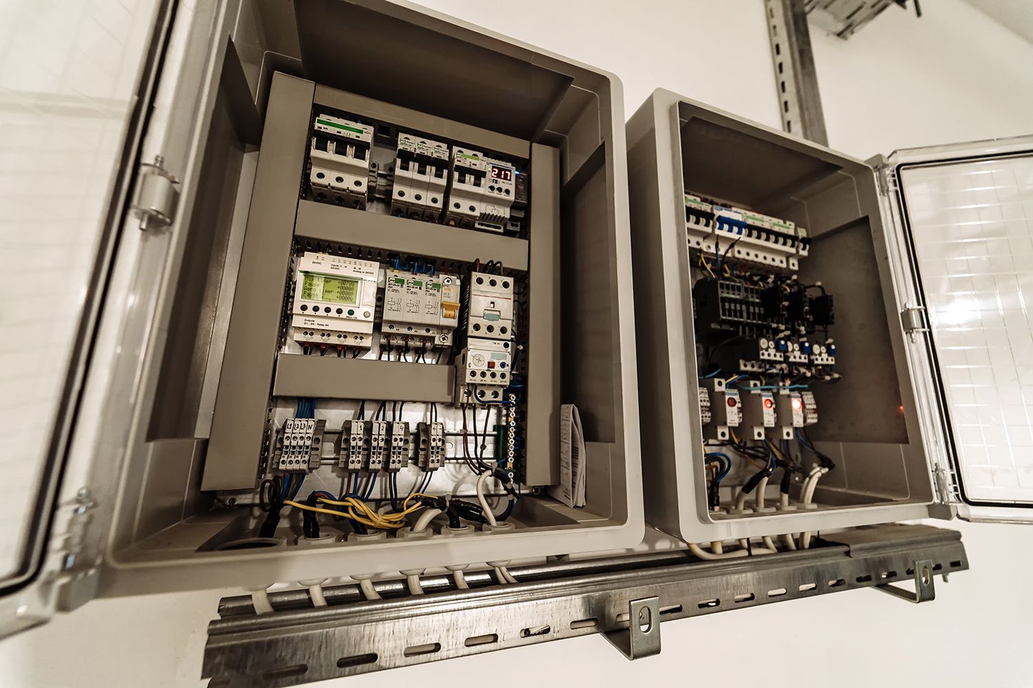 Open electrical control panel with circuit breakers and wiring in a metal enclosure