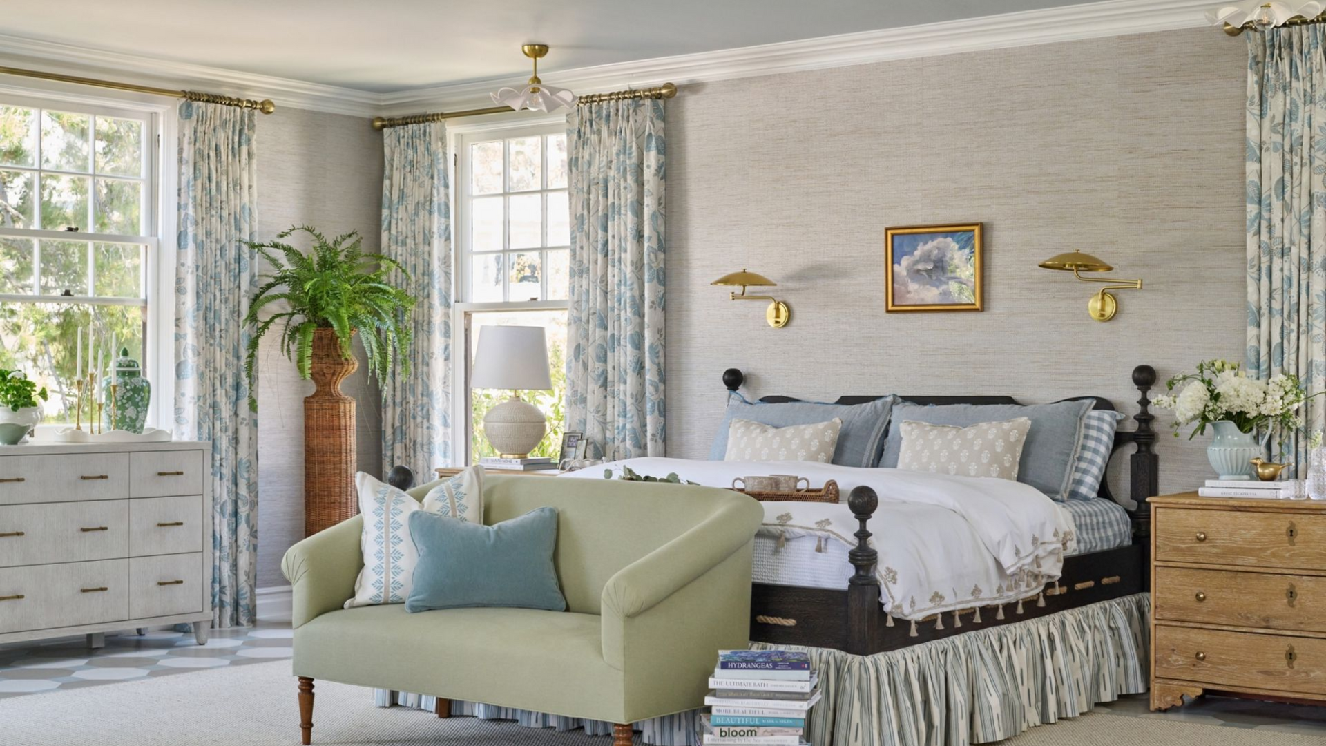 Elegant bedroom with light blue accents. Includes bed, sofa, dresser, and windows with patterned curtains.