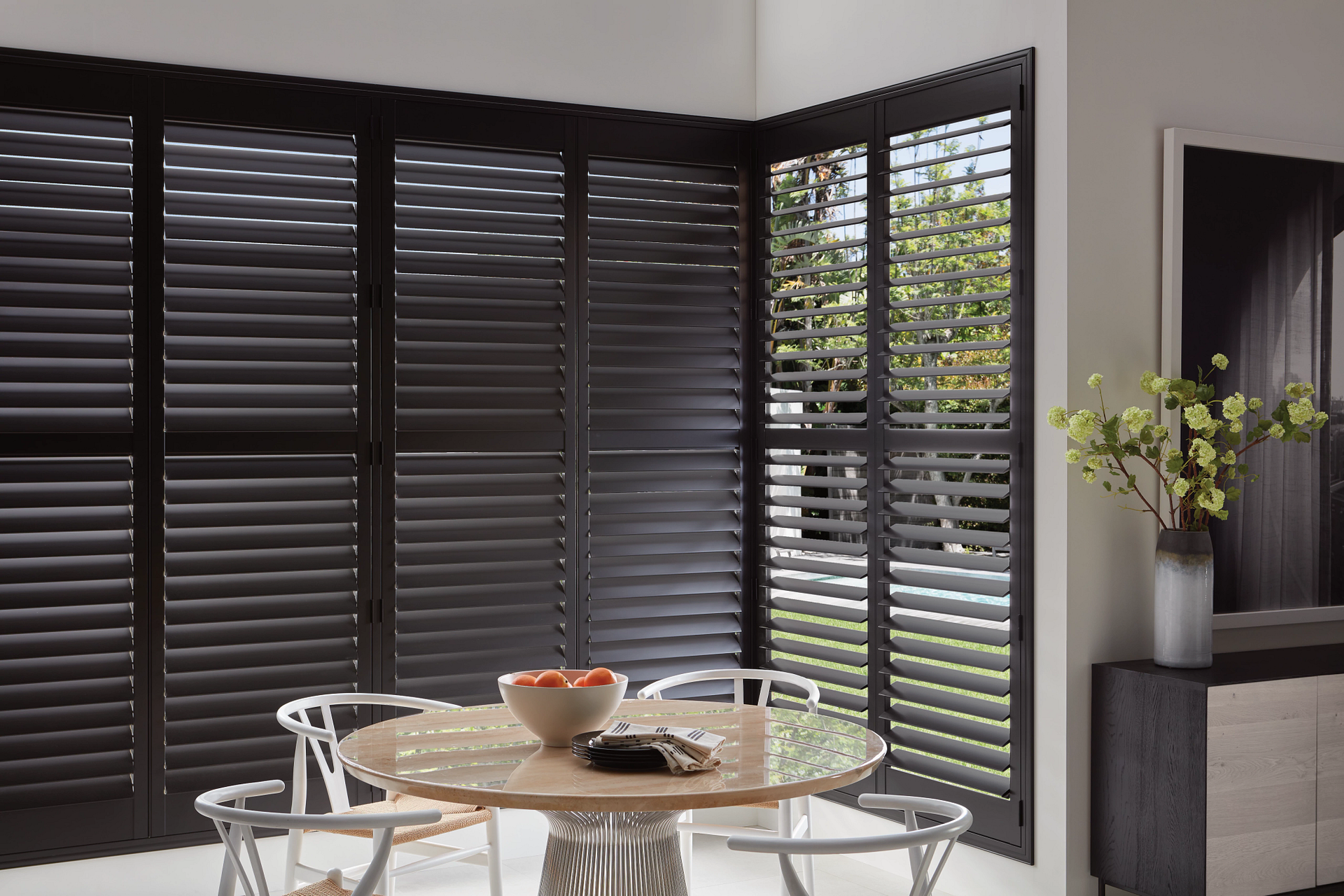 Hunter Douglas Heritance® Wood Shutters in a black stain on large windows in a kitchen