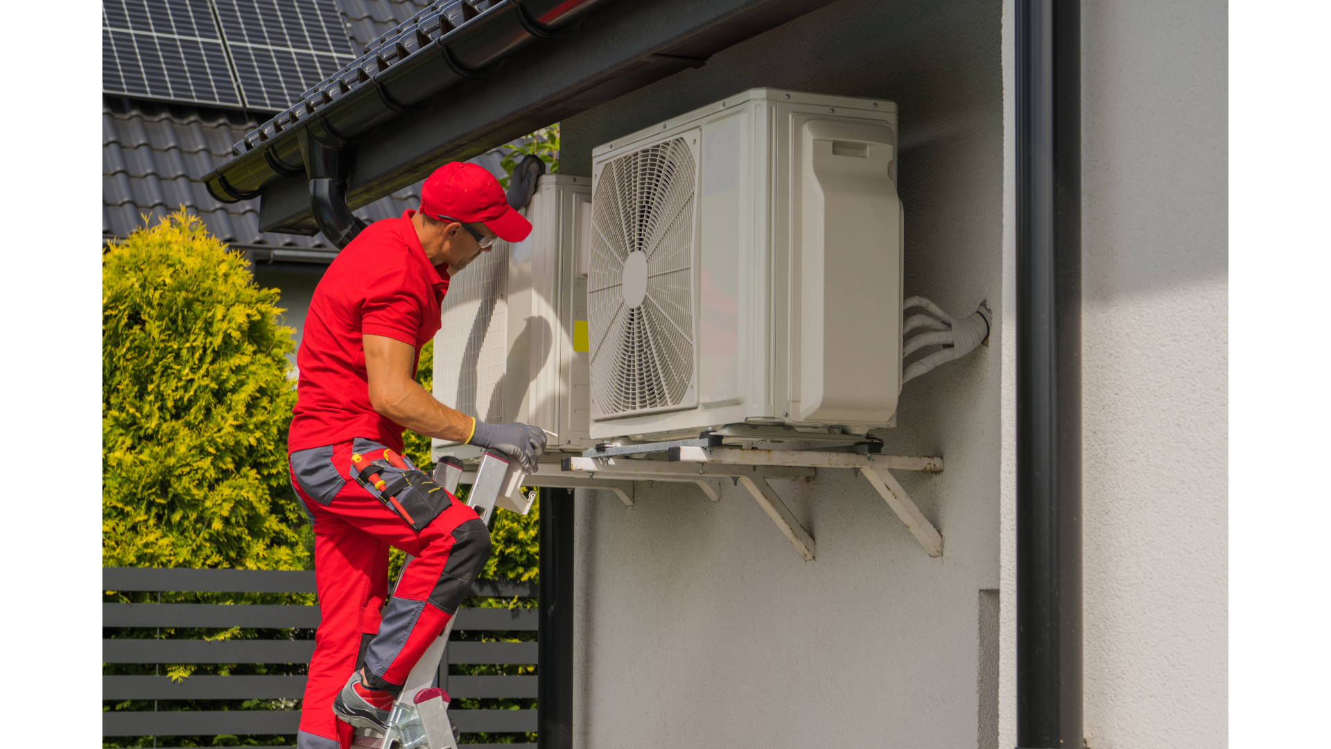 A man is installing an air conditioner on the side of a building.