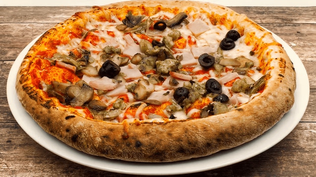A pepperoni, olive, mushroom, and artichoke pizza on a white plate